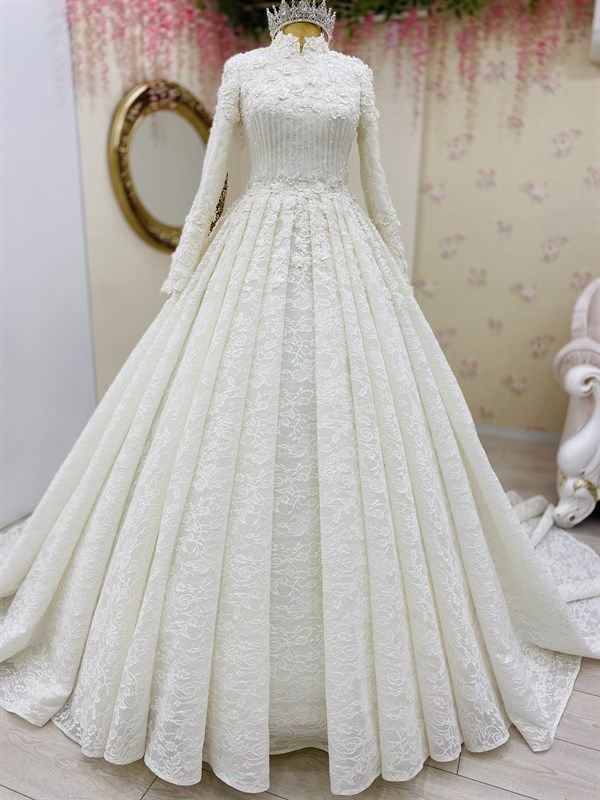 White lace wedding dress on a mannequin with a decorative background