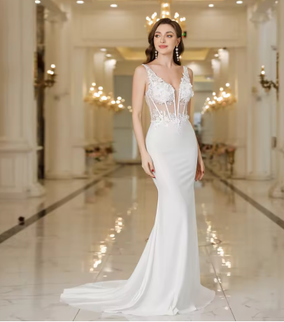 Woman in a white evening gown standing in an elegant indoor setting.